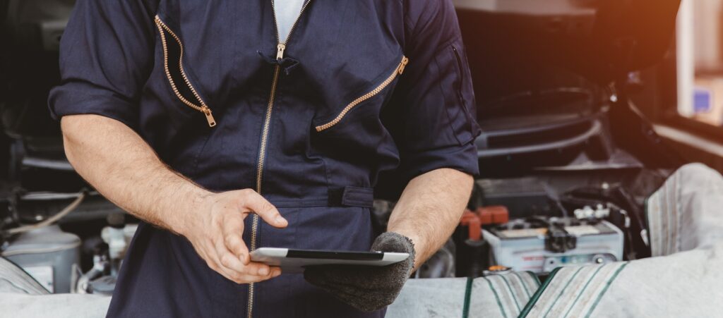 Garage technician worker using tablet computer advance technology for service checking and tuning